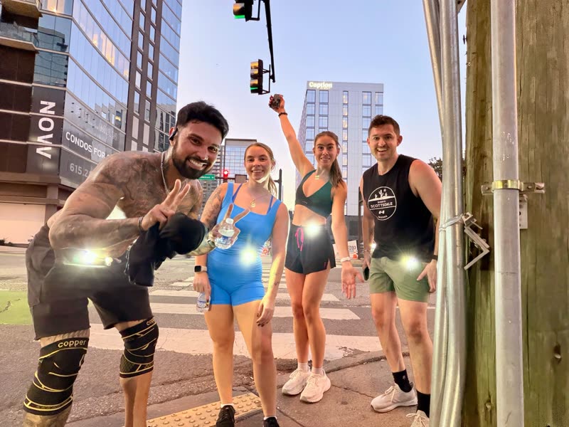 QNTM Run Club members running downtown Nashville at night wearing lights